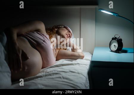 Pregnant woman suffers from pain at night.  Stock Photo