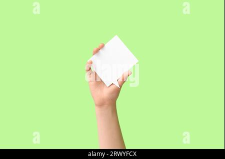 Woman holding blank speech bubble on green background Stock Photo