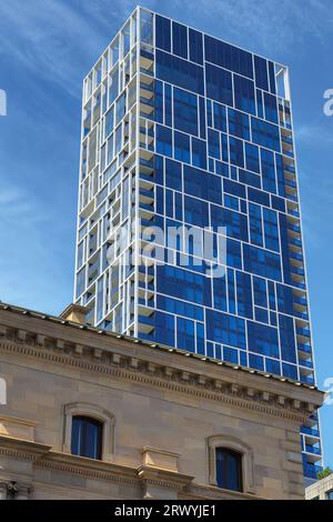 946 Blue glass facade of modern habitational building on Spring Street seen over the Old Treasury Building. Melbourne-Australia. Stock Photo