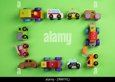 Frame of different toy vehicles for children on green background, flat lay. Space for text Stock Photo