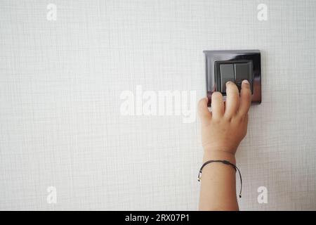 child finger turning on lighting switch with copyspace  Stock Photo
