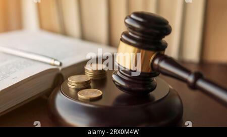 Judge gavel and Euro coins at court. Mallet of a judge deciding on financial corruption and tax fraud. Selective focus on the rings. Stock Photo