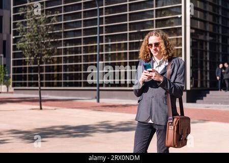 smiling young business man using mobile phone Stock Photo