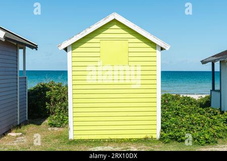 Frontal view of the back of a green wooden bathing hut on the beach of Skanör med Falsterbo at the Öresund in the morning sun, Skåne, Sweden Stock Photo