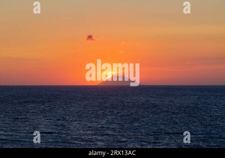 Tropea Calabria Italy. The sun sets in the crater mouth of Stromboli volcano Stock Photo