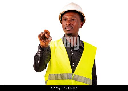 Young male construction engineer wearing a green vest and a white safety helmet while using invisible screen. Stock Photo