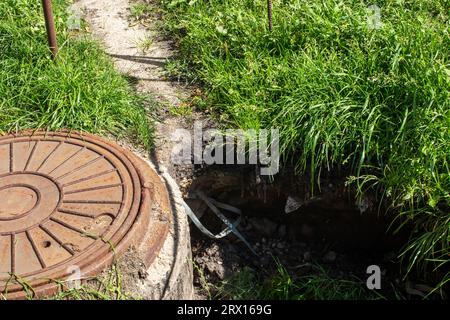 A hole in the ground and a manhole close up Stock Photo