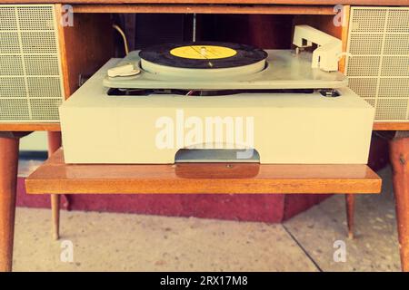old vintage player of plate.   First musical record-player of disks. Retro turntable. Vinyl player with plates. Stock Photo