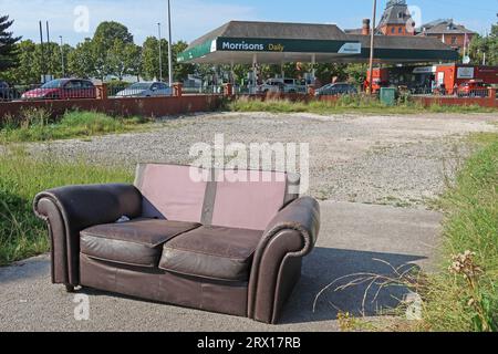 Fly-tipping on waste ground, an abandoned furniture sofa, Stockton Heath, Warrington, Cheshire, England, UK, WA4 6RN Stock Photo