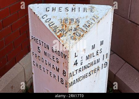 Cheshire County Council white metal mile post 1898 - to Lymm, Manchester, Altrincham, at Stockton Heath A49, A56 junction, Warrington, England, UK, Stock Photo