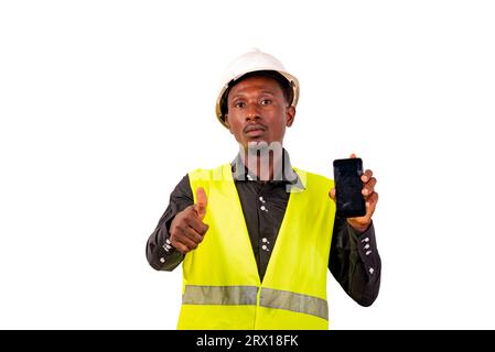 entrepreneur man with hard hat standing on white background cheerful showing phone wearing making gesture of approval. Stock Photo