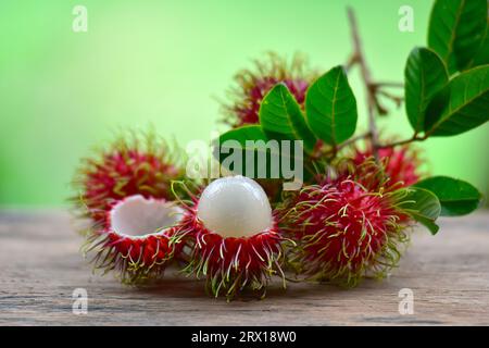 Fresh and ripe rambutan sweet tropical fruit peeled rambutan with leaves, Rambutan fruit on wooden background harvest from the garden Stock Photo