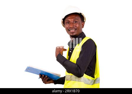 young male inspector architect holding clipboard while pointing index finger back smiling. Stock Photo
