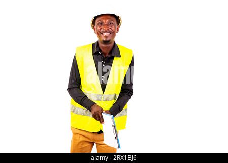 young man inspector architect wearing green vest and holding clipboard while smiling. Stock Photo
