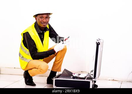 young happy engineer man wearing white glove in a toolbox while smiling. Stock Photo