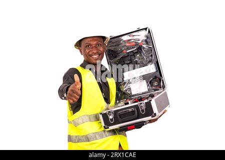 young male technician wearing green vest and holding toolbox while showing his thumb up smiling. Stock Photo