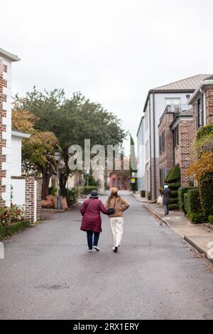 Young Woman and Older Woman Walking Down a Charming City Street Stock Photo