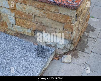 Sand stone wall surface, background of decorate. Stoneware cladding has fallen off the facade of the building. Brown wall of rough stone, background, Stock Photo