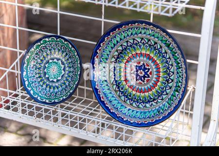 Decorative ceramic plates with traditional uzbek ornament in street market of Bukhara. Uzbekistan Stock Photo