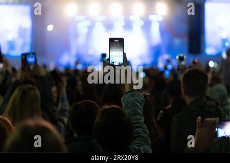 hands using camera phone to take pictures and videos at live concert, smartphone records live music festival, Take photo in front concert stage, happy Stock Photo