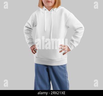 Mockup of a white hoodie on a fair-haired girl in jeans, front view, kid's clothes with a pocket, ties. Long sleeve template with hood for design, pat Stock Photo