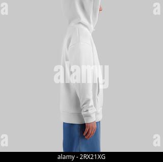 Mockup of white hoodie on blonde girl in jeans, side view, sweatshirt with hood, pocket, ties. Kid's clothes template for design, print, pattern, isol Stock Photo