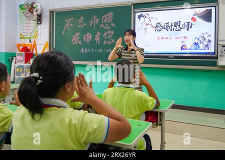 Luannan County, China - September 7, 2022: Elementary school students are practicing gratitude teachers' sign language exercises in the classroom. Stock Photo