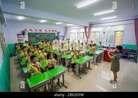 Luannan County, China - September 7, 2022: Elementary school students are practicing gratitude teachers' sign language exercises in the classroom. Stock Photo