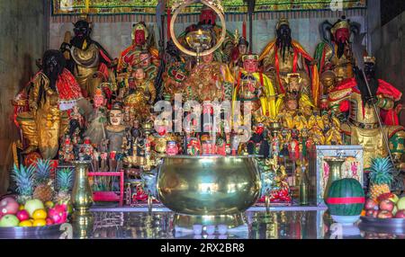 Figurines of deities in chinese Jui Tui temple in Phuket, Thailand. China shrine worship shelf with many gods, selective focus Stock Photo