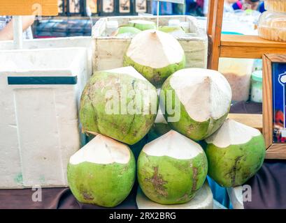 Fresh green coconuts on counter selling on street market Stock Photo