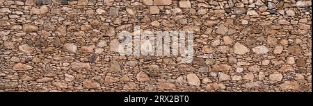 Brown panoramic natural stone wall with pattern of big and small stones Stock Photo