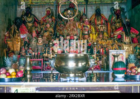 Figurines of deities in chinese Jui Tui temple in Phuket, Thailand. China shrine worship shelf with many gods, selective focus Stock Photo