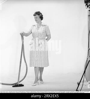 Cleaning day in the 1960s. A woman is standing holding a vacuum cleaner, looking happy. Sweden 1960. Kristoffersson ref CN109-5 Stock Photo