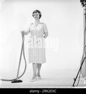 Cleaning day in the 1960s. A woman is standing holding a vacuum cleaner, looking happy. Sweden 1960. Kristoffersson ref CN109-8 Stock Photo