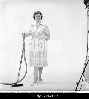 Cleaning day in the 1960s. A woman is standing holding a vacuum cleaner, looking happy. Sweden 1960. Kristoffersson ref CN109-7 Stock Photo