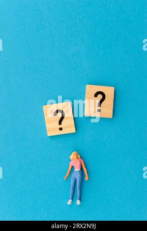 woman miniature figurine, question mark and exclamation mark Stock Photo