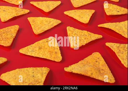Pattern of Tortilla chips on a red background. Stock Photo