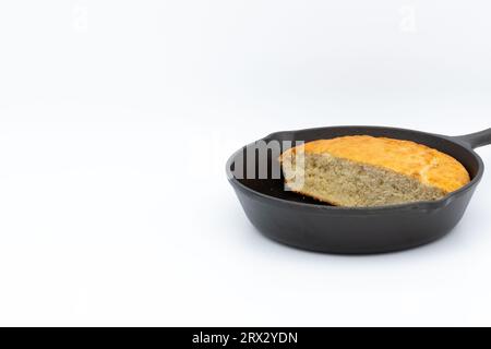 Golden brown homemade cornbread in a black cast iron skillet. Cornbread is commonly associated with cuisine of the southern USA Stock Photo