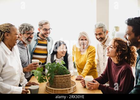 Happy multiracial friends with different ages and ethnicities having fun drinking coffee at home Stock Photo