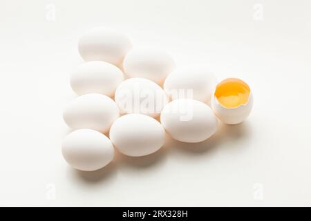 White eggs on a white background, one egg is broken, unlike the others. High quality photo Stock Photo