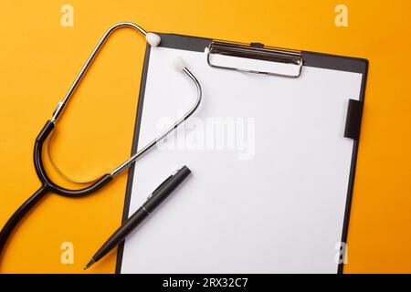 Stethoscope in doctors desk with tablet, pen and pills. Top view with place for your text. Stock Photo