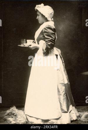 Chambermaid, Handmaid, Housemaid, Maidservant late 1800s, early 1900s carrying Tray Stock Photo