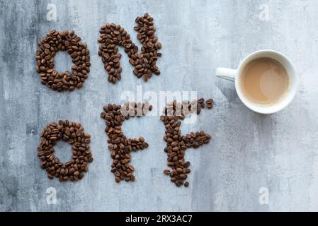 cup of coffee as a switch between ON and OFF beans, gray stone background, morning or waking up concept Stock Photo