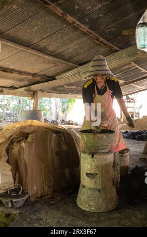 A person making clay bucket stoves by hand in Cambodia. Stock Photo