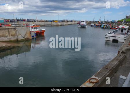 Seahouses, UK - 13 July, 2023: Fishing boats in Seahouses Harbour, Northumberland Stock Photo