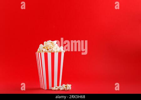 Glass with popcorn on a red background close-up Stock Photo
