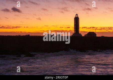 Point Arena Lighthouse at sunset, with storm coming in off the pacific ocean with high surf and crashing waves. The lighthouse is located on the Point Stock Photo