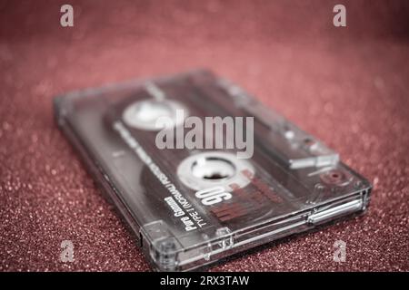 Close-up shot of an old retro audio tape on red background Stock Photo