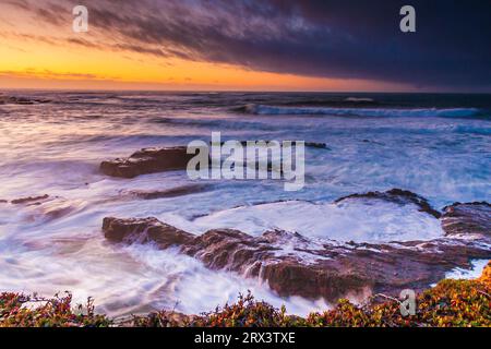 Sunset with stormy weather and high surf at Point Arena Lighthouse peninsula on the rocky pacific coast of northern California. The white-capped, cras Stock Photo