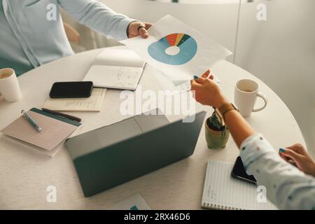 Close up of business colleagues analysts working with documents together sitting in office Stock Photo